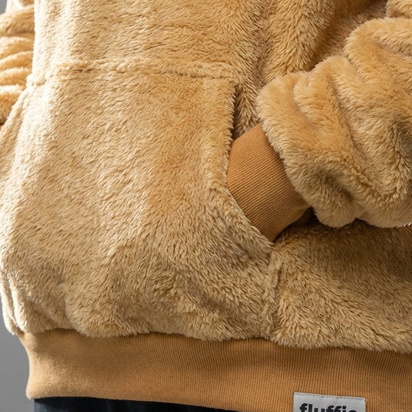 Close-up of a fluffy beige hoodie with a pocket and 'fluffle' label